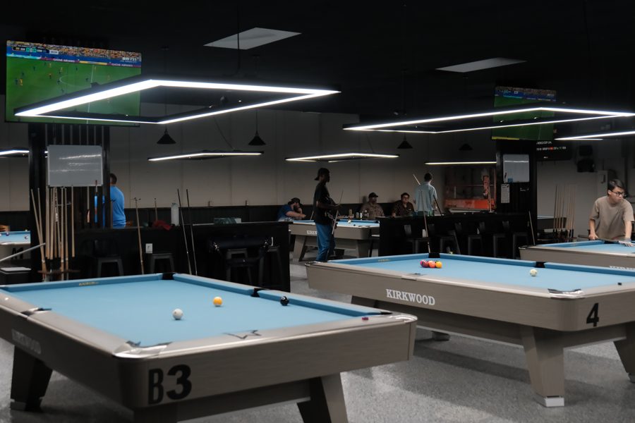 Panoramic view of the hall showing all Kirkwood tables and the bar area lit up